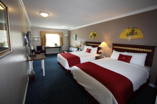 a hotel room with two beds and a living room at The Revelstoke Gateway Inn in Revelstoke