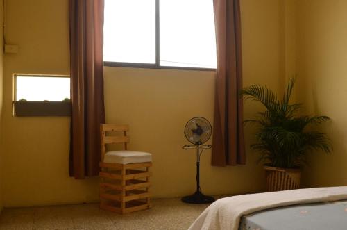 a bedroom with a fan and a window at Pachamac House in Guayaquil