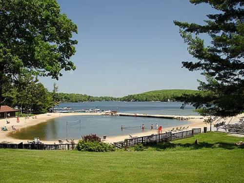 a beach with a bunch of people on it at Split Rock Resort in Lake Harmony