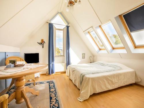 een slaapkamer met een bed, een bureau en ramen bij Comfy holiday home in Hoorn with garden in Hoorn