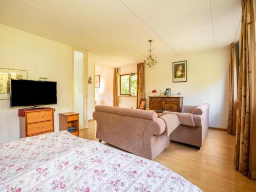 a living room with a couch and a tv at Comfy holiday home in Hoorn with French balcony in Hoorn