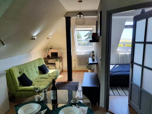 un salon avec un canapé vert et une chambre dans l'établissement Zöld Relax Apartments, à Budakeszi