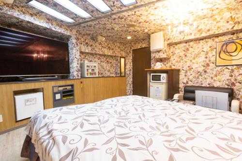 a bedroom with a bed and a tv in it at ファインリゾート in Nagoya