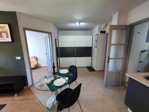 a living room with a glass table and chairs at Zöld Relax Apartments in Budakeszi