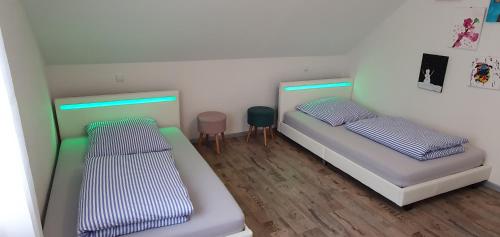 Cette chambre comprend deux lits, une table et une chaise. dans l'établissement Ferienwohnung Nova, à Tholey
