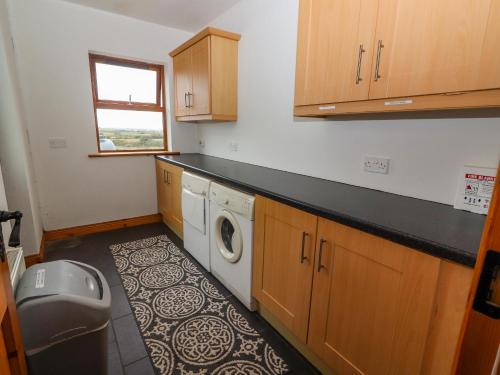 una lavanderia con lavatrice e asciugatrice di Cherry Blossom Cottage a Ennis