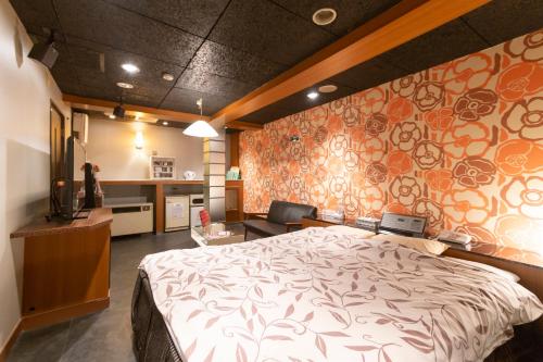 a bedroom with a large bed and a kitchen at ファインリゾート in Nagoya