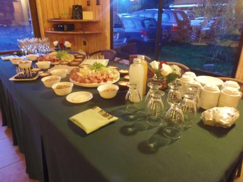 a table with a green table cloth with food on it at Hotel Departamentos del Sur in Puerto Montt