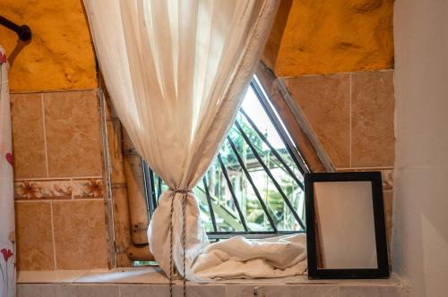 ventana con cortinas y espejo en una habitación en Chalet Ecoturismo La Nohelia, en Jericó