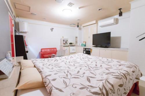 a bedroom with a bed and a tv in it at ファインリゾート in Nagoya