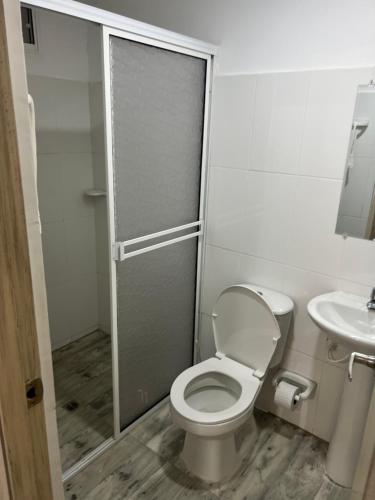 a bathroom with a toilet and a sink at Hostal Taganga Plaza in Taganga
