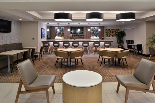 a bar in a restaurant with tables and chairs at Holiday Inn Hotel & Suites Overland Park-Convention Center, an IHG Hotel in Overland Park