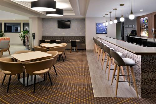a bar in a restaurant with tables and chairs at Holiday Inn Hotel & Suites Overland Park-Convention Center by IHG in Overland Park