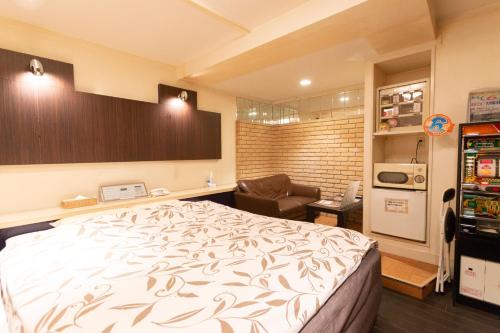 een slaapkamer met een bed en een stoel erin bij ファインリゾート in Nagoya
