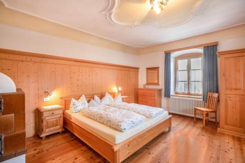 - une chambre avec un grand lit et une fenêtre dans l'établissement Pausahof - Apartment Abendsonne, à Trodena