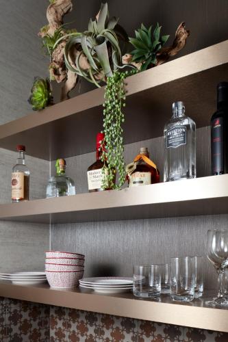 a shelf with dishes and bottles and glasses on it at THesis Hotel Miami Coral Gables, Curio Collection by Hilton in Miami