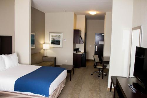 um quarto de hotel com uma cama e uma secretária em Holiday Inn Express and Suites Sikeston, an IHG Hotel em Sikeston