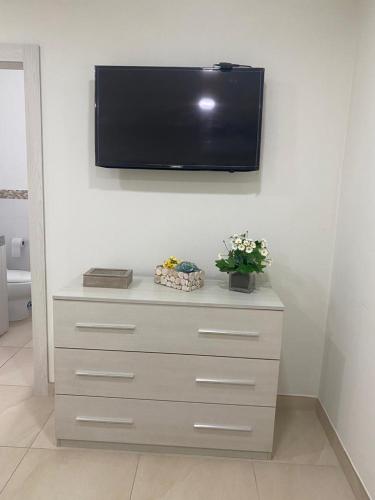 a dresser with a flat screen tv on a wall at Alquilo hermoso departamento en Salinas, Ecuador in Salinas
