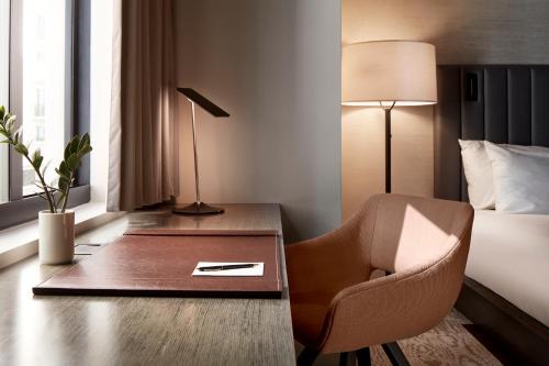 a hotel room with a desk and a chair and a bed at THesis Hotel Miami Coral Gables, Curio Collection by Hilton in Miami