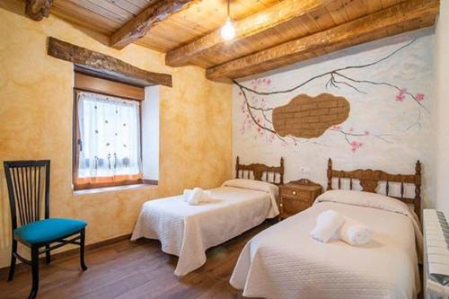 a bedroom with two beds and a heart painted on the wall at House of the Ribera - Quintana del Puente in Quintana del Puente