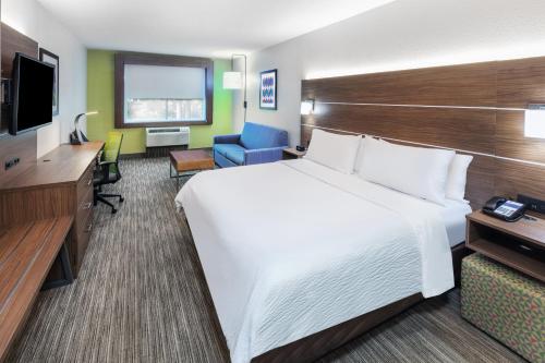 a hotel room with a large bed and a desk at Holiday Inn Express & Suites Lafayette South by IHG in Lafayette