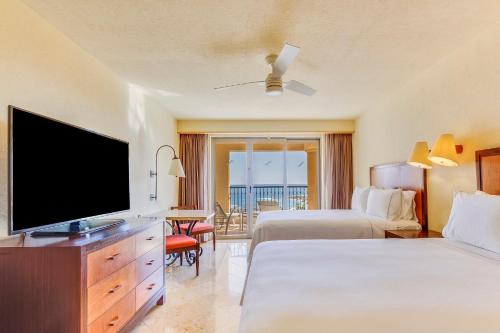 um quarto de hotel com duas camas e uma televisão de ecrã plano em Grand Fiesta Americana Los Cabos All Inclusive Golf & Spa em Cabo San Lucas