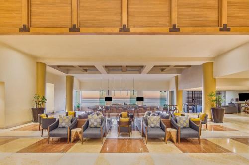 an open living room with chairs and a bar at Grand Fiesta Americana Los Cabos All Inclusive Golf & Spa in Cabo San Lucas