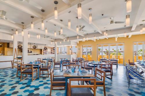 a dining room with blue tables and chairs at Grand Fiesta Americana Los Cabos All Inclusive Golf & Spa in Cabo San Lucas