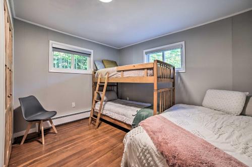 1 Schlafzimmer mit 2 Etagenbetten und einem Stuhl in der Unterkunft Secluded Suttons Bay Retreat with Fire Pit! in Suttons Bay