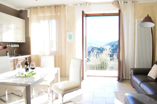 Una cocina y una sala de estar con una mesa y sillas blancas. en Apartment with Beautiful Sun, en Montepulciano