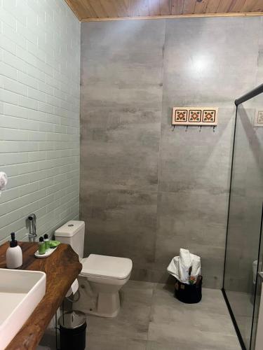 a bathroom with a toilet and a shower at Pousada Canto da Nascente in Monte Verde