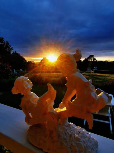 a statue of two children on a bench at sunset at Country Villa Estate in Ngongotaha