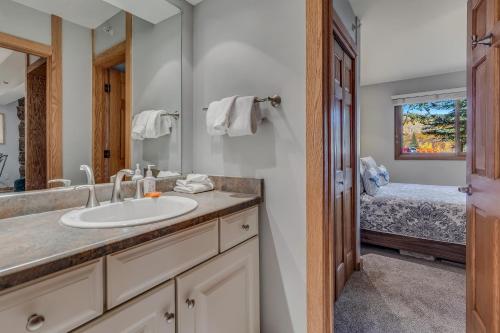 baño con lavabo, espejo y cama en Laurelwood Condominiums 202 en Snowmass Village