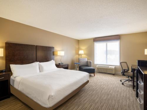 a hotel room with a bed and a desk at Holiday Inn Express Gas City by IHG in Gas City