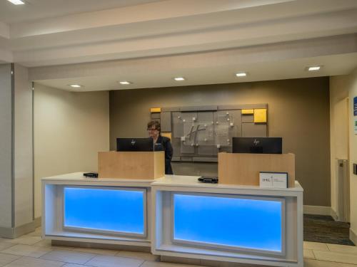 a man standing behind a counter with boxes at Holiday Inn Express Gas City by IHG in Gas City