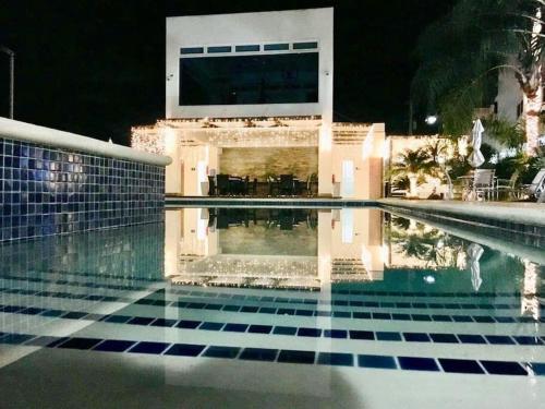 a swimming pool in front of a house at night at Elegante Blue Marine Apartamento Juan Dolio in Juan Dolio