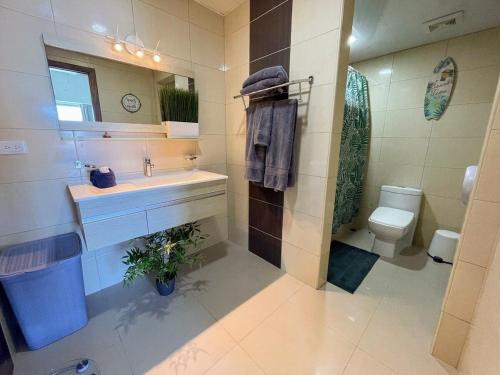a bathroom with a sink and a toilet and a mirror at Elegante Blue Marine Apartamento Juan Dolio in Juan Dolio
