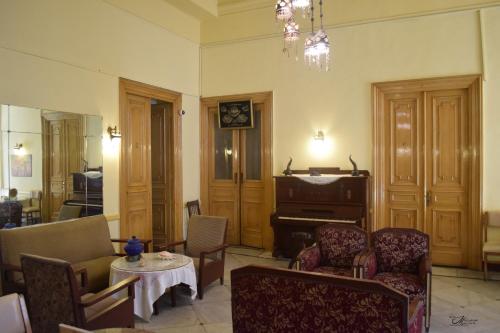 a living room with a piano and a table and chairs at Clement's House Hostel in Alexandria