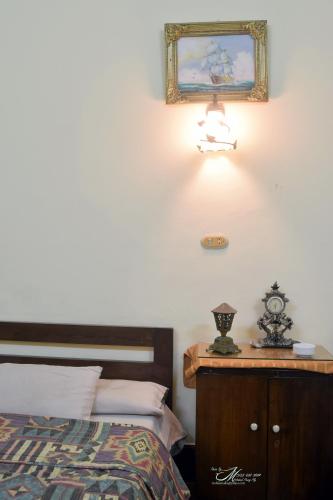 a bedroom with a bed and a light on the wall at Clement's House Hostel in Alexandria