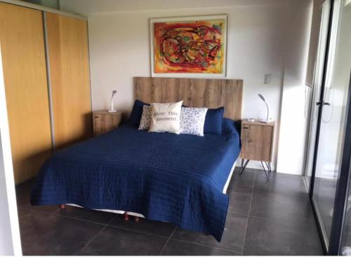 1 dormitorio con 1 cama con sábanas y almohadas azules en Villa General Belgrano - Puerto del Águila in 