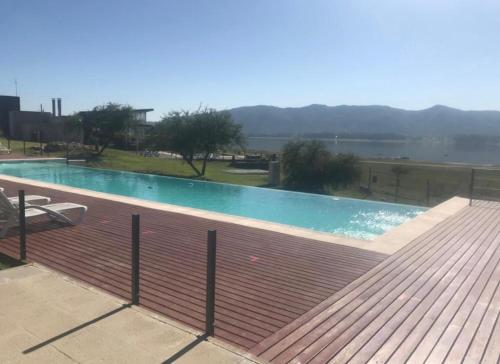 una gran piscina con terraza de madera en Villa General Belgrano - Puerto del Águila in 