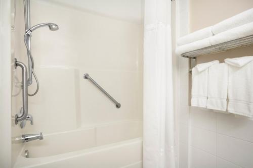 a bathroom with a shower and a bathtub with towels at Days Inn & Suites by Wyndham Langley in Langley