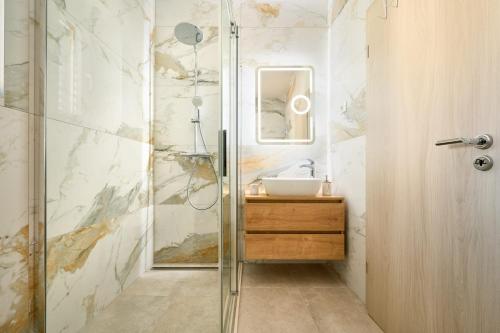 a bathroom with a glass shower and a sink at Zora Residence in Kaštela
