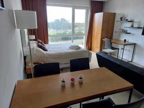 a room with a table and a bedroom with a bed at Condominios W Nordelta Bahia,Tigre,Parking,Gym in Tigre