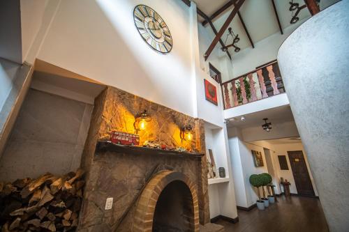 a room with a fireplace with a clock on the wall at Vistas del Conde in Heredia