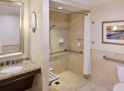 a bathroom with a shower and a sink and a toilet at Balboa Bay Resort in Newport Beach