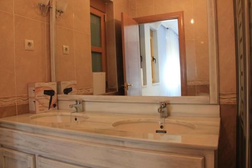een badkamer met een wastafel en een grote spiegel bij Casa Nueva en Barco frente a Sierra de Gredos in El Barco de Ávila