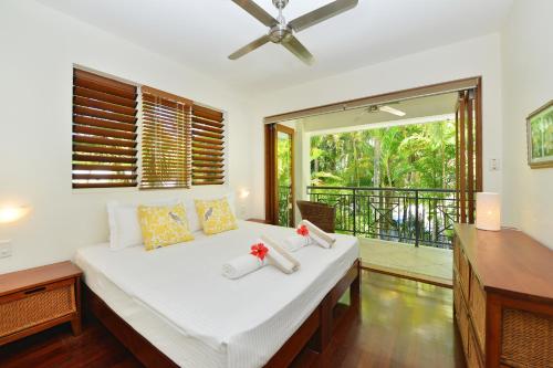 una camera con un grande letto e un balcone di Villa Frangipani a Port Douglas