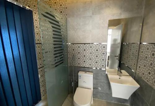 a bathroom with a toilet and a sink and a mirror at فلل اسوار الوسام الفندقية in Taif