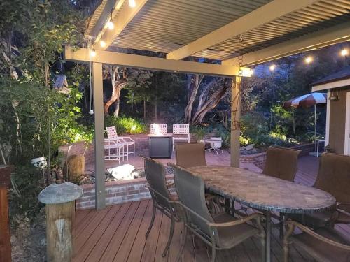 a patio with a table and chairs on a deck at CASA de los ARBOLES! Delight & Solitude Abound! in Pine Cove